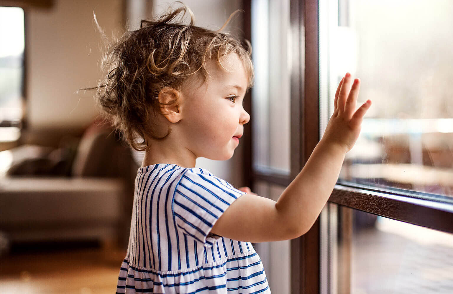 Ein kleines Mädchen steht am Fenster 