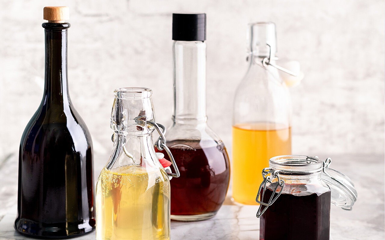 Diverse gefüllte Flaschen mit Essig und Öl