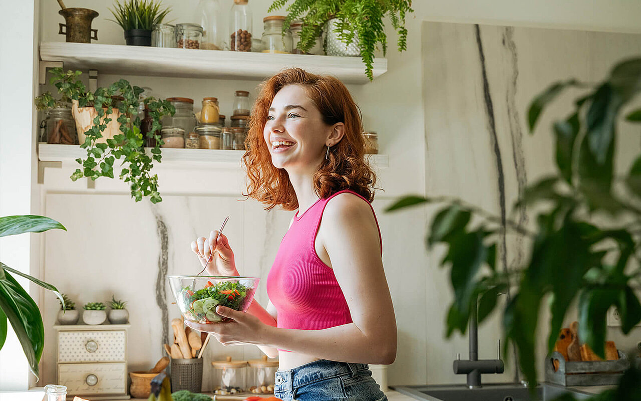Eine Frau steht in einer grünen Küche